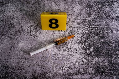 crime investigation. syringe near yellow marker number 8 on marble background. High quality photo clipart