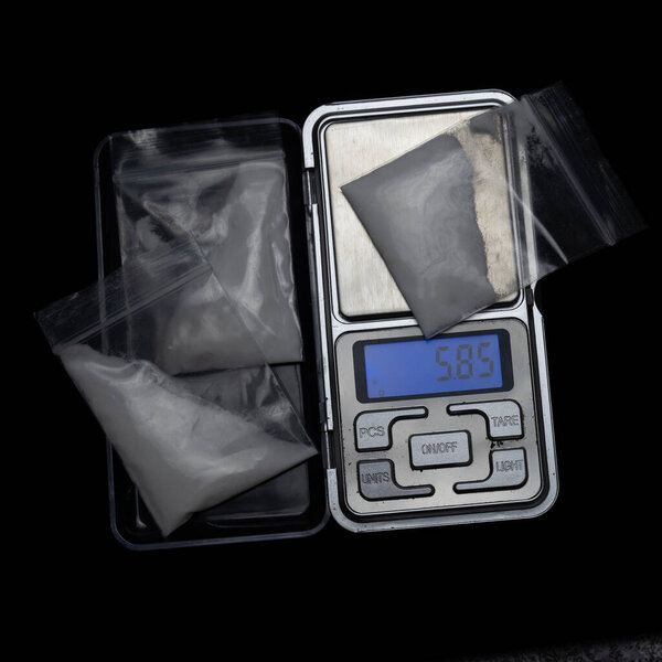 On a tabletop digital scale a bag of white powder. concept drug sale. High quality photo