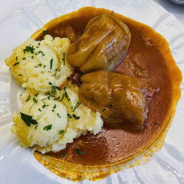 Beyaz bir tabakta servis edilen et ve patates püresiyle doldurulmuş iki biber. Yüksek kalite fotoğraf