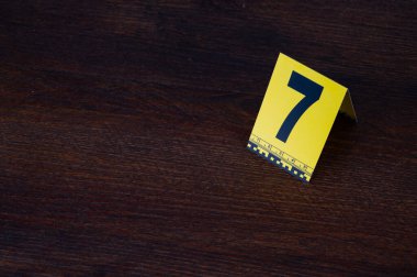 Yellow crime scene evidence marker number 7 on the floor in the room. High quality photo clipart