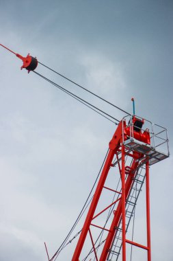 Gökyüzüne karşı Kablolar ve Operatör Kabini ile Parlak Kırmızı Turna Üst Yapısı