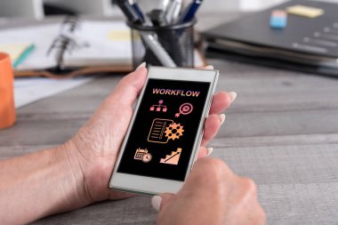 İş akışı konsepti olan akıllı telefonu tutan bir kadın.