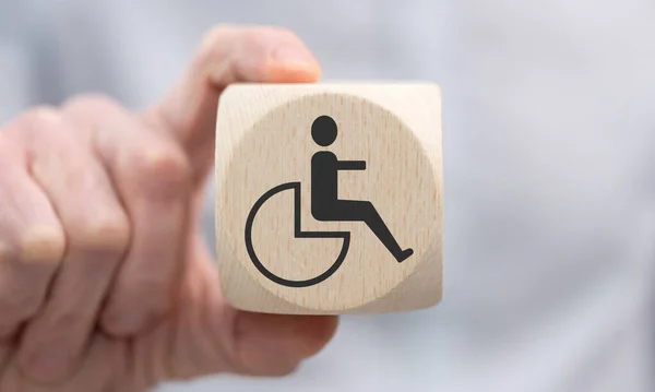 Ręcznie Trzymając Drewnianą Kostkę Symbolem Niepełnosprawności — Zdjęcie stockowe