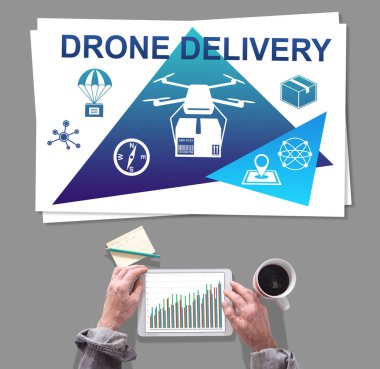 Erkek eller İHA teslimat konseptinin önünde tablet kullanıyor.