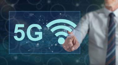 Bir adam dokunmatik ekranda 5G konseptine parmağıyla dokunuyor.