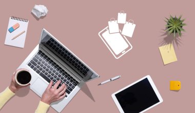 Çevrimiçi alışveriş kavramının sembolü olan dizüstü bilgisayar kullanan ellerin üst görünümü