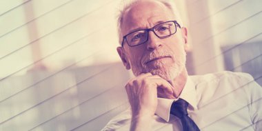 Portrait of mature businessman sitting in office, geometric pattern