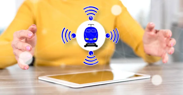 Digital tablet with smart train concept between hands of a woman in background