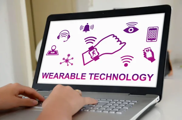 Hands on a laptop with screen showing wearable technology concept
