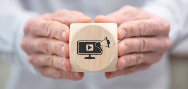 Hand holding a wooden cube with symbol of online marketing concept