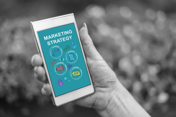 Женщина держит смартфон с концепцией маркетинговой стратегии
