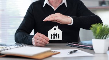 Insurer protecting a family and a house with his hand