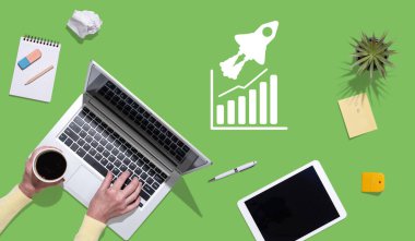 Büyüme kavramının sembolü olan dizüstü bilgisayar kullanan ellerin üst görünümü