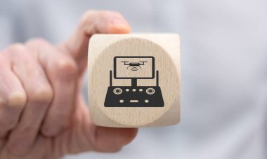 Elinde insansız hava aracı konseptinin sembolü olan tahta bir küp var.