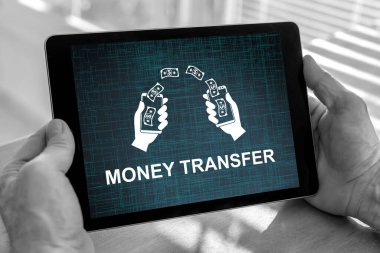 Male hands holding a tablet with money transfer concept