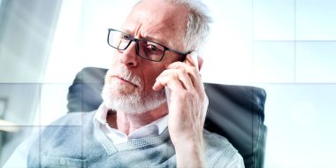 Portrait of bearded senior businessman talking on mobile phone in office, light effect, geometric pattern
