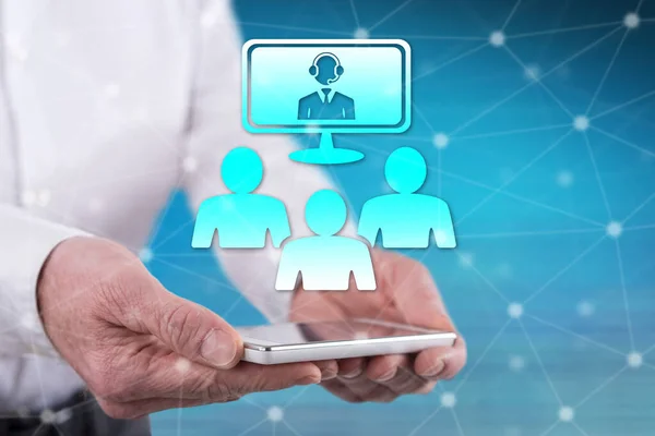 Stock image Video conference concept above a smartphone held by hands