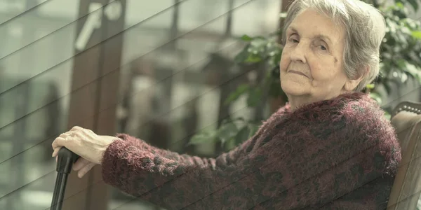 Oude Vrouw Zittend Met Haar Handen Een Stok Geometrisch Patroon — Stockfoto
