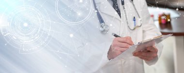 Doctor taking notes on clipboard in medical office; panoramic banner