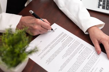 Bir sözleşme imzalayan iş kadınının eli (Lorem ipsum metni)