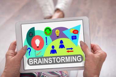 Bir kadının elinde tuttuğu tablette beyin fırtınası konsepti görülüyor.