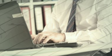 Ofiste dizüstü bilgisayarda yazan işadamı, geometrik desen