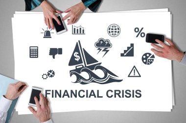 Finansal kriz kavramı, akıllı telefonları kullanan ellerle masaya yerleştirilmiş.