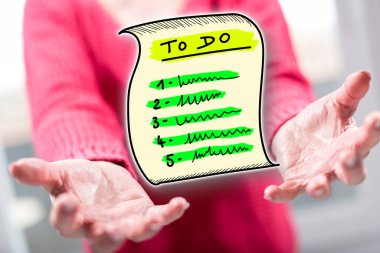 Liste konseptini arka plandaki bir kadının elinin üstünde tutmak.