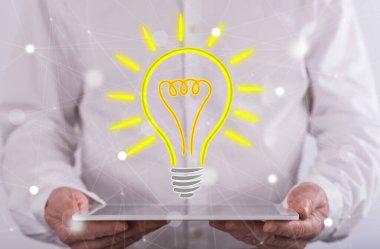 Arka planda bir adam tarafından düzenlenen bir tablet üzerinde parlak fikir kavramı