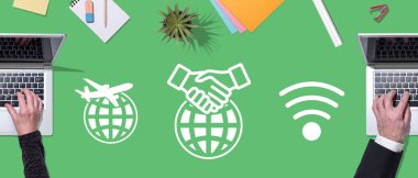 Küreselleşme kavramının sembolü olan dizüstü bilgisayar kullanan ellerin üst görünümü