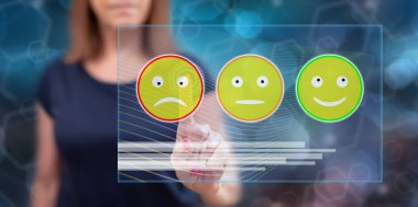 Kadın dokunmatik ekranda müşteri memnuniyeti kavramına parmağıyla dokunuyor.