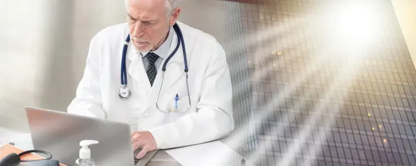 Tıbbi Ofiste Dizüstü Bilgisayar Kullanan Kıdemli Doktor Çoklu Pozlama — Stok fotoğraf