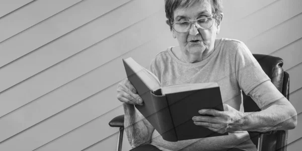 Γριά Γυναίκα Κάθεται Διαβάζοντας Ένα Βιβλίο Γεωμετρικό Μοτίβο — Φωτογραφία Αρχείου
