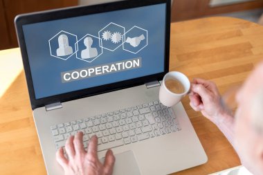 Ekranda işbirliği konsepti olan bir dizüstü bilgisayar kullanan adam