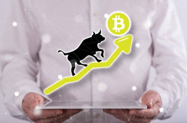 Bitcoin kabadayı eğilimi arka planda bir adamın tuttuğu tabletin üzerinde