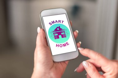 Akıllı telefonda akıllı ev konsepti bir el tarafından tutuldu