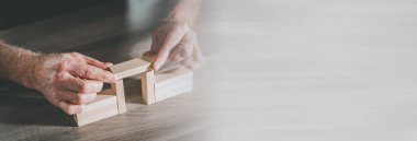 Eller ahşap bir köprü inşa ediyor; iş birliği kavramı; panoramik pankart