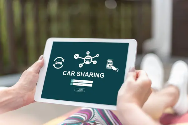 Female hands holding a tablet with car sharing concept
