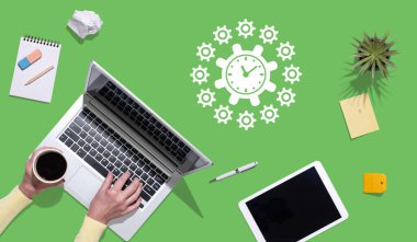 Zaman yönetimi kavramının sembolü olan dizüstü bilgisayar kullanan ellerin üst görünümü