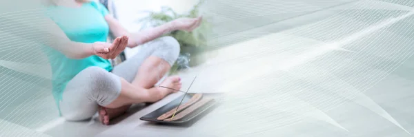 Woman doing yoga in an incense atmosphere; panoramic banner