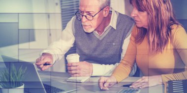 Ofiste dizüstü bilgisayarda çalışan iki olgun iş arkadaşı, geometrik desen