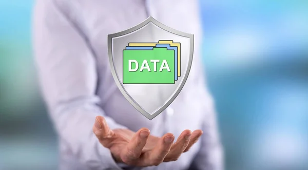 Data protection concept above the hand of a man in background