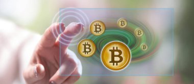 Kadın dokunmatik ekranda bitcoin para birimine dokunuyor.