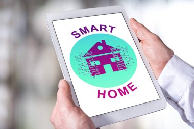 Elinde tablet tutan adam akıllı ev kavramını gösteriyor