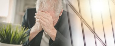 İş yerinde oturan çok çalışan ve yorgun kıdemli işadamı.