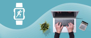 Giyilebilir teknoloji sembolü olan dizüstü bilgisayar kullanan ellerin üst görünümü