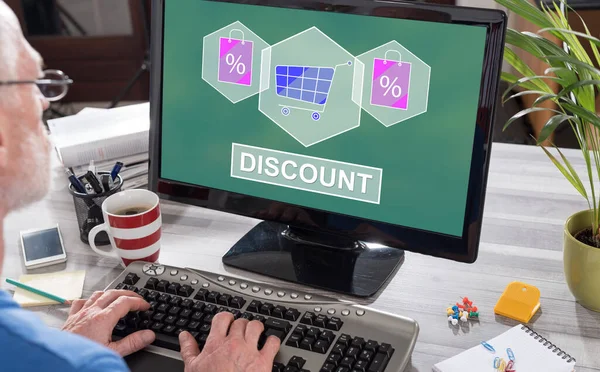 Man using a computer with discount concept on the screen
