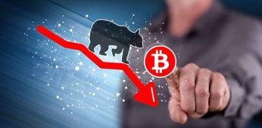 Dokunmatik ekranda bir bitcoin 'e dokunan adam ayı eğilimi kavramına parmağıyla dokunuyor