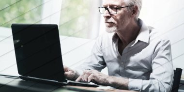 Ofiste dizüstü bilgisayarda çalışan olgun iş adamı, geometrik desen