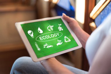 Ekoloji kavramını gösteren bir tablet tutan kadın.